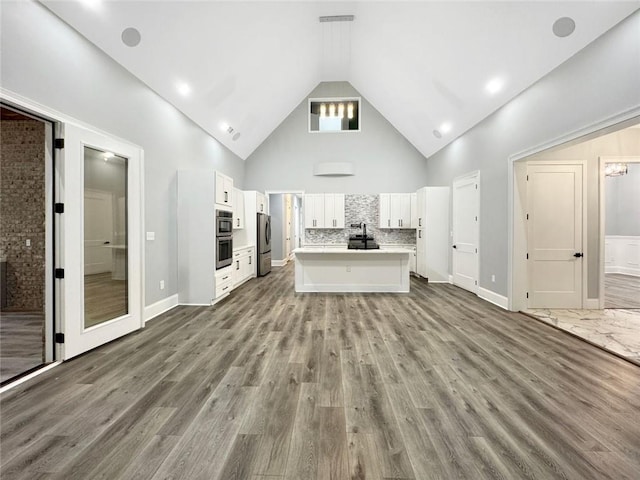 244 Coastline Rd, Fayetteville, GA 30214 - unfurnished living room with high vaulted ceiling, wood finished floors, a sink, and baseboards