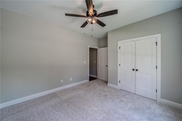 unfurnished bedroom featuring ceiling fan, light colored carpet, and a closet