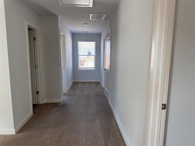 corridor with carpet floors, baseboards, and visible vents