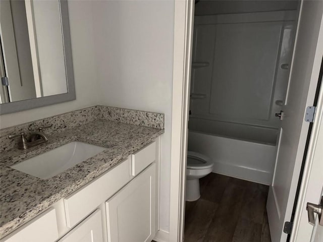 bathroom featuring wood finished floors, shower / tub combination, vanity, and toilet