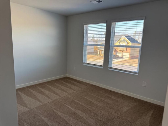 unfurnished room with carpet and baseboards