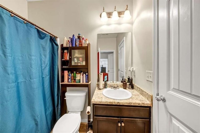 bathroom with curtained shower, vanity, and toilet