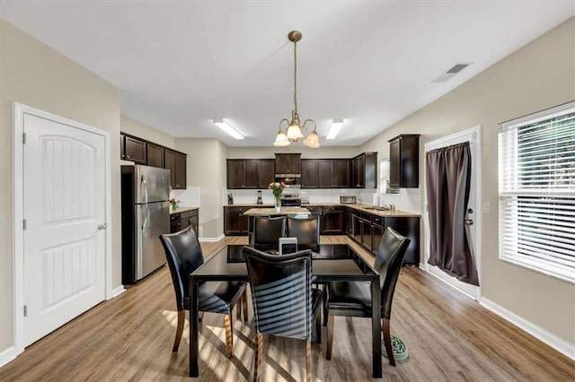 dining area featuring an inviting chandelier and light hardwood / wood-style flooring