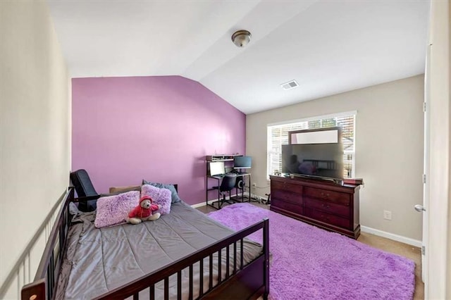 bedroom featuring light colored carpet and vaulted ceiling