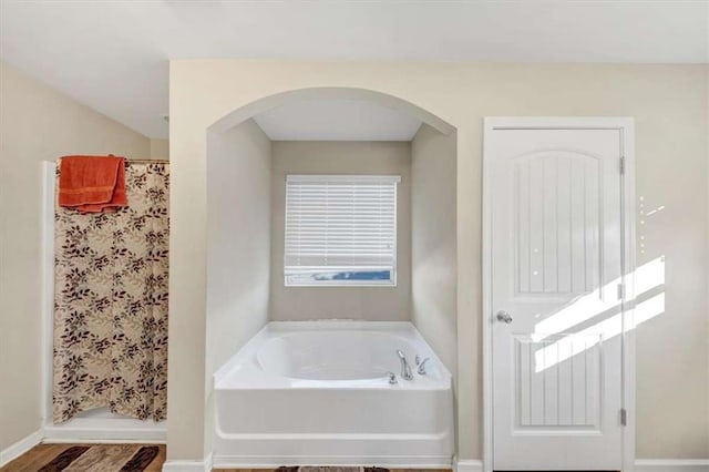 bathroom with hardwood / wood-style floors and independent shower and bath