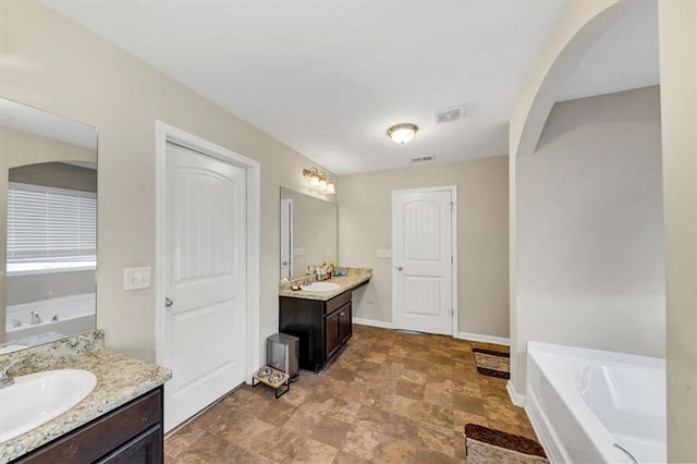 bathroom featuring vanity and a tub to relax in