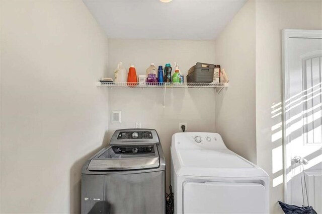 clothes washing area with washing machine and clothes dryer