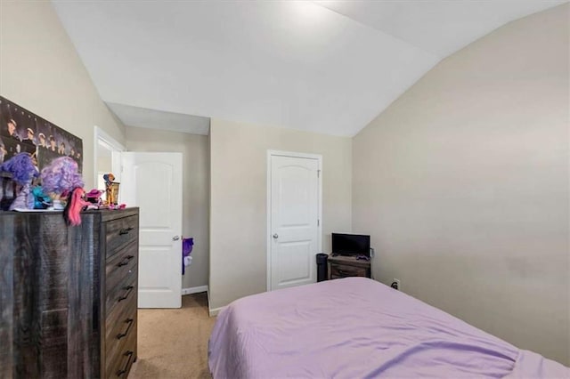 bedroom with light colored carpet and lofted ceiling