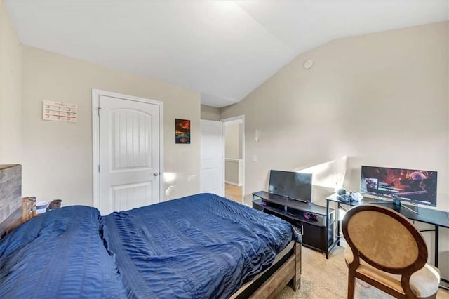 bedroom featuring light colored carpet and vaulted ceiling