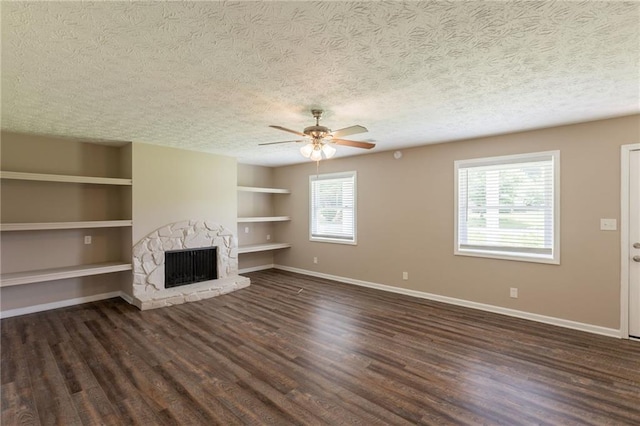 225 Fireside Way, Fairburn, GA 30213 - unfurnished living room featuring a textured ceiling, baseboards, built in shelves, dark wood-style flooring, and ceiling fan