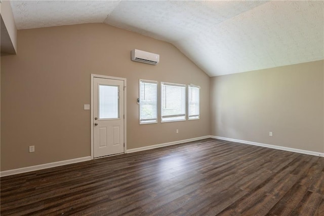 225 Fireside Way, Fairburn, GA 30213 - additional living space featuring lofted ceiling, an AC wall unit, dark wood-style floors, a textured ceiling, and baseboards