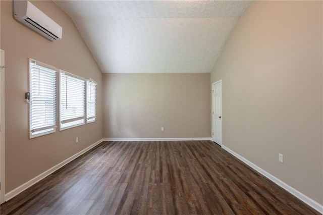 225 Fireside Way, Fairburn, GA 30213 - empty room with vaulted ceiling, a wall mounted AC, dark wood-style floors, and baseboards