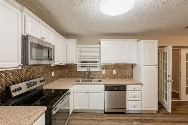 225 Fireside Way, Fairburn, GA 30213 - kitchen featuring stainless steel appliances, a sink, dark wood-style floors, white cabinets, and light countertops