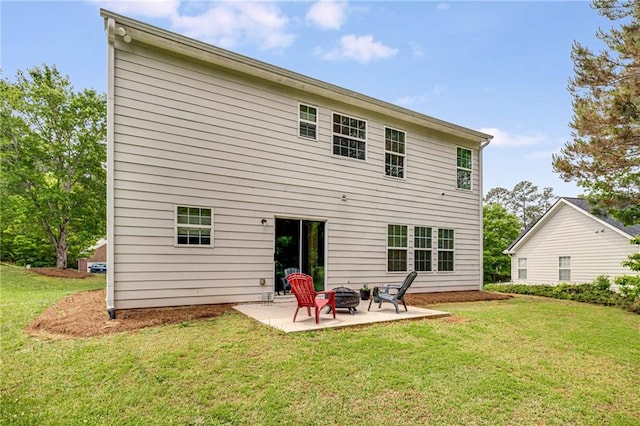 back of house featuring a yard, a patio, and a fire pit