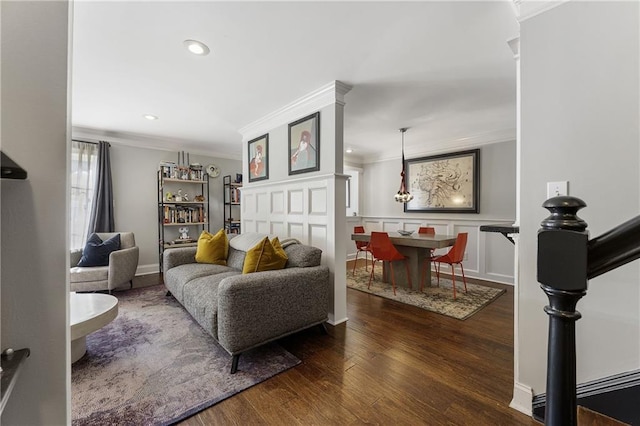 living room featuring ornamental molding, recessed lighting, wood finished floors, and a decorative wall