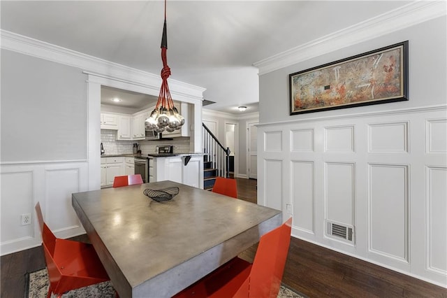 dining area with dark wood-style floors, crown molding, visible vents, a decorative wall, and stairway