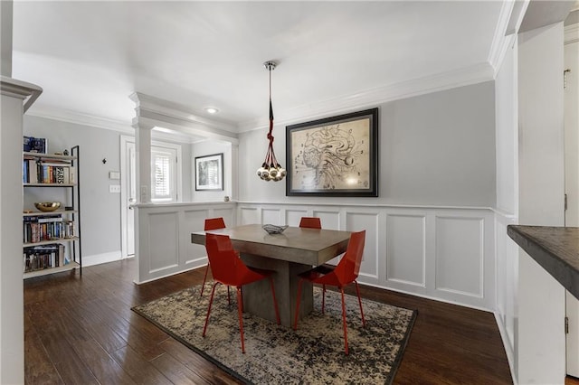 dining room with ornamental molding, dark wood-type flooring, and a decorative wall