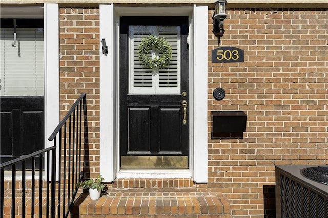 doorway to property featuring brick siding