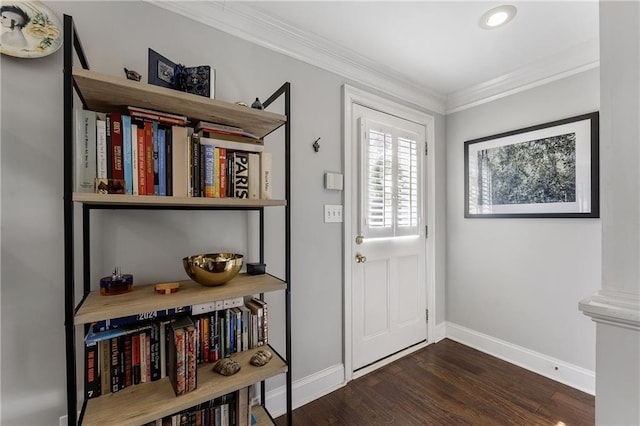 entryway with dark wood-style floors, crown molding, and baseboards