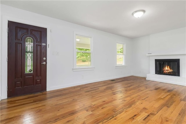 3781 Cherokee Trl, Suwanee, GA 30024 - unfurnished living room featuring wood finished floors, baseboards, and a brick fireplace