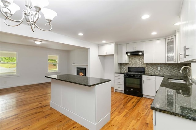 3781 Cherokee Trl, Suwanee, GA 30024 - kitchen featuring a sink, tasteful backsplash, black gas range oven, under cabinet range hood, and a chandelier