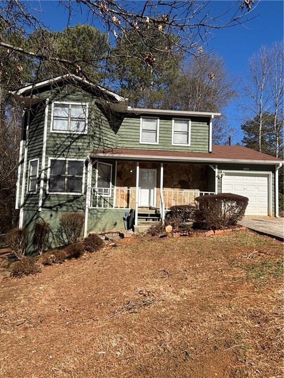 view of property with a garage and covered porch