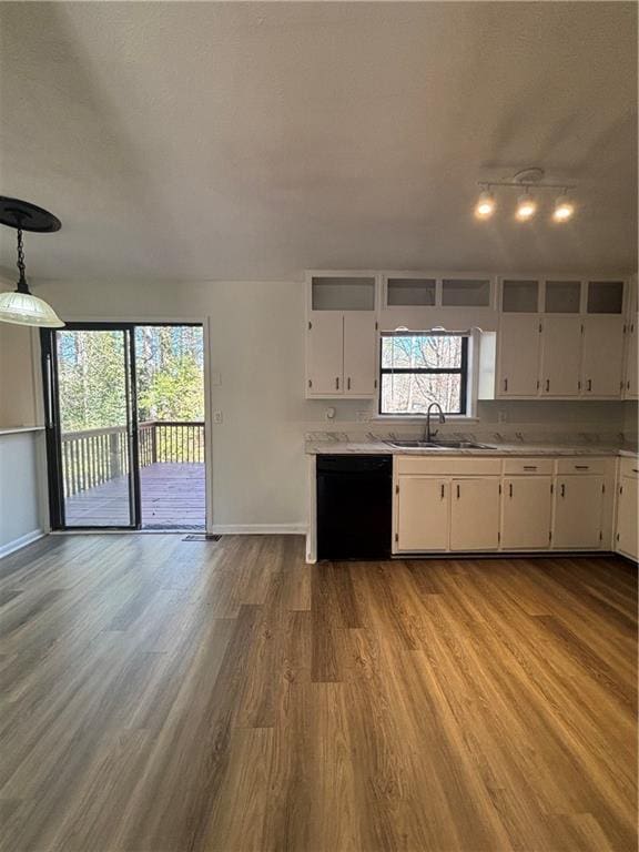 kitchen with sink, white cabinetry, light hardwood / wood-style flooring, black dishwasher, and pendant lighting