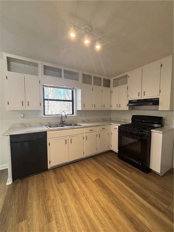 kitchen with white cabinetry, sink, light hardwood / wood-style floors, and black appliances