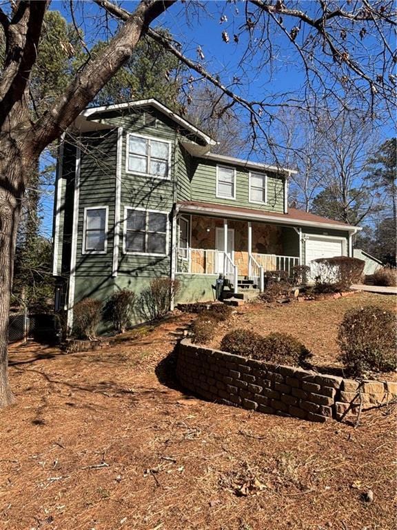 view of front property featuring a garage and covered porch