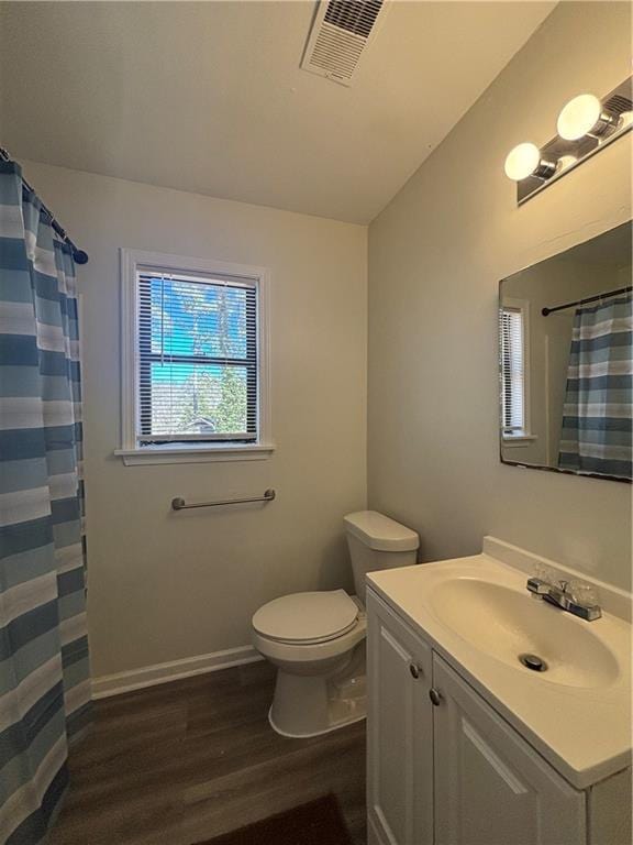 bathroom with wood-type flooring, toilet, curtained shower, and vanity