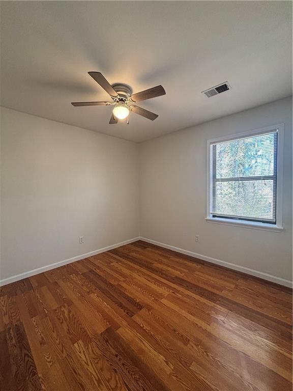 unfurnished room featuring dark hardwood / wood-style floors and ceiling fan