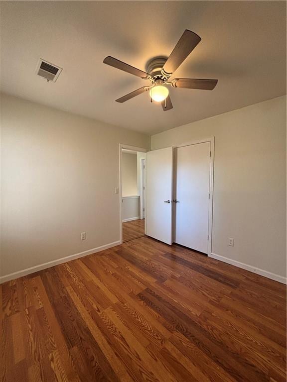 unfurnished bedroom featuring dark wood-type flooring and ceiling fan