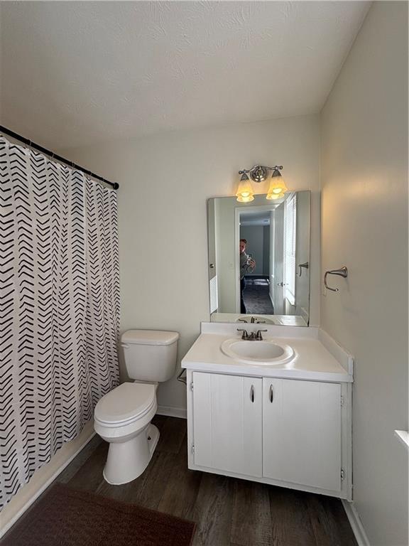 bathroom with vanity, hardwood / wood-style floors, toilet, and walk in shower