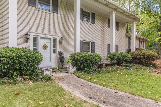 entrance to property featuring a lawn