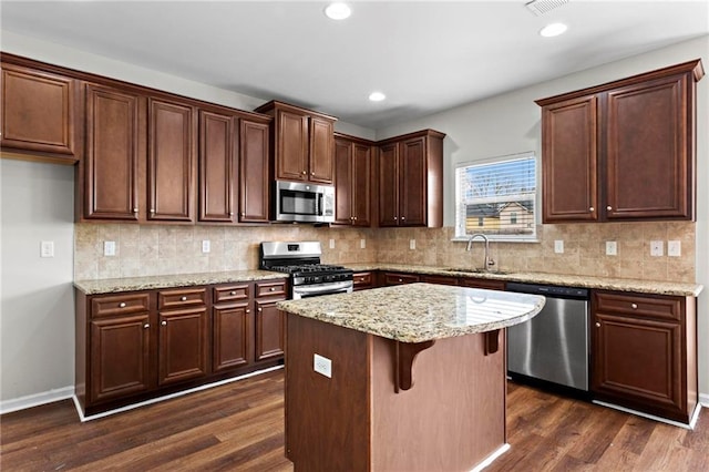 kitchen with recessed lighting, backsplash, dark wood-type flooring, appliances with stainless steel finishes, and a sink