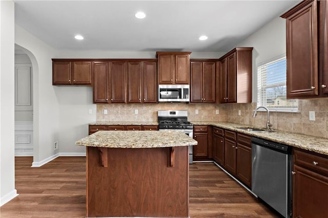 kitchen featuring decorative backsplash, dark wood-style flooring, a sink, and stainless steel appliances
