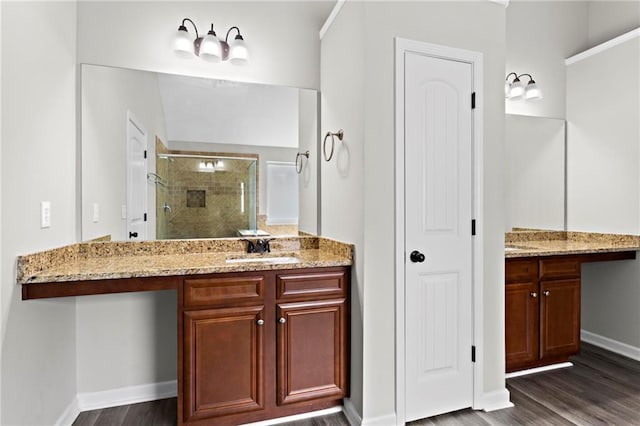 full bathroom featuring a shower stall, wood finished floors, vanity, and baseboards
