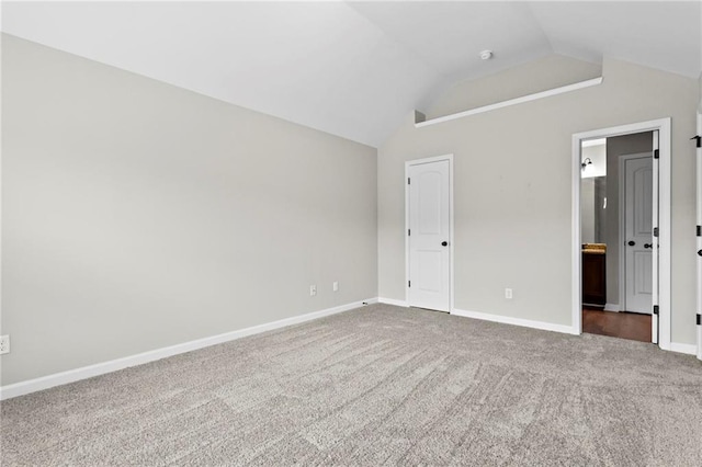 unfurnished bedroom with baseboards, carpet, and vaulted ceiling