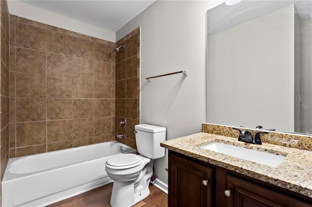bathroom featuring toilet, wood finished floors, vanity, and washtub / shower combination