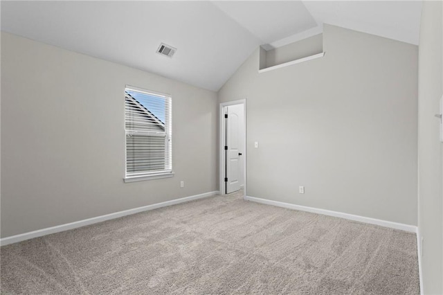 carpeted empty room with baseboards, lofted ceiling, and visible vents