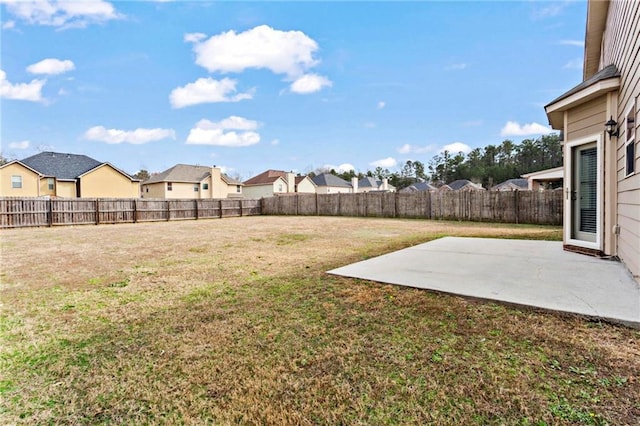 view of yard with a patio, a fenced backyard, and a residential view