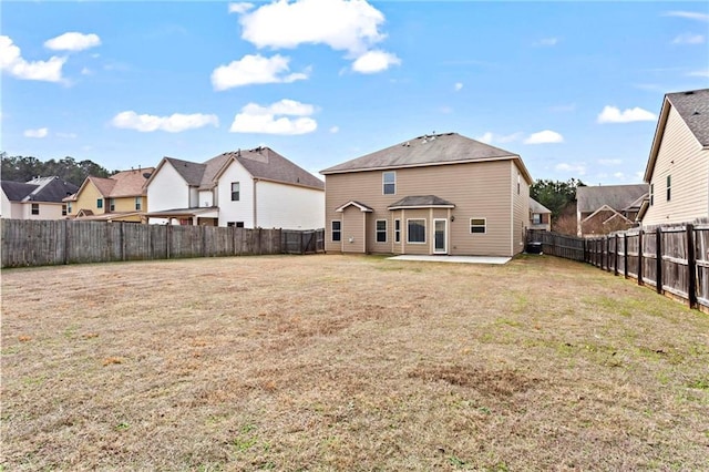 back of property with a patio area, a fenced backyard, a residential view, and a lawn