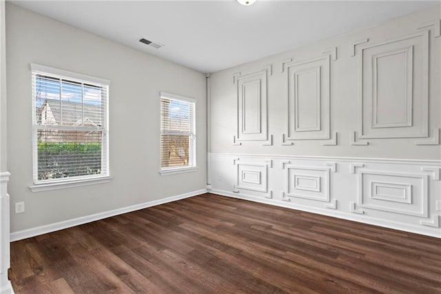 unfurnished bedroom featuring dark wood-type flooring, baseboards, and visible vents