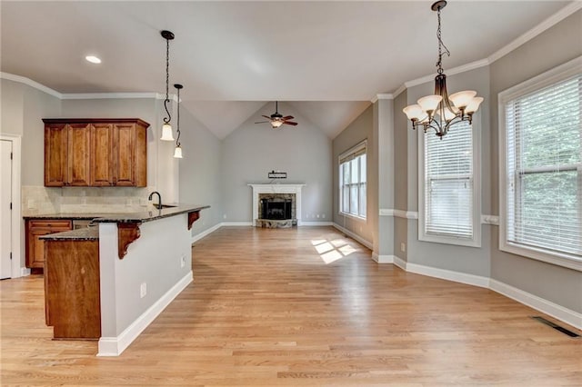5195 Stefan Ridge Way, Buford, GA 30519 - kitchen featuring ceiling fan with notable chandelier, brown cabinets, a kitchen breakfast bar, light wood-style flooring, and open floor plan