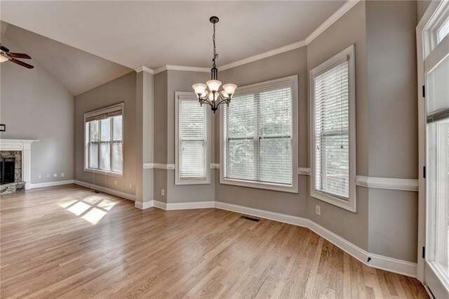 5195 Stefan Ridge Way, Buford, GA 30519 - unfurnished dining area featuring light wood-style flooring, baseboards, a stone fireplace, visible vents, and ceiling fan with notable chandelier