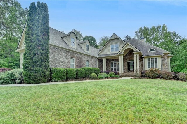 5195 Stefan Ridge Way, Buford, GA 30519 - craftsman-style house with brick siding, a shingled roof, a front lawn, and a chimney