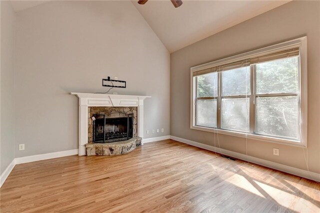 5195 Stefan Ridge Way, Buford, GA 30519 - unfurnished living room featuring ceiling fan, wood finished floors, baseboards, and a stone fireplace