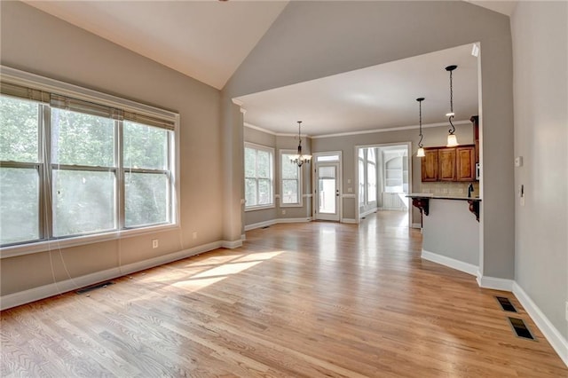 5195 Stefan Ridge Way, Buford, GA 30519 - unfurnished living room featuring an inviting chandelier, light wood-style flooring, and baseboards