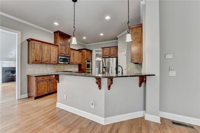 5195 Stefan Ridge Way, Buford, GA 30519 - kitchen with brown cabinets, stainless steel appliances, dark stone countertops, and visible vents