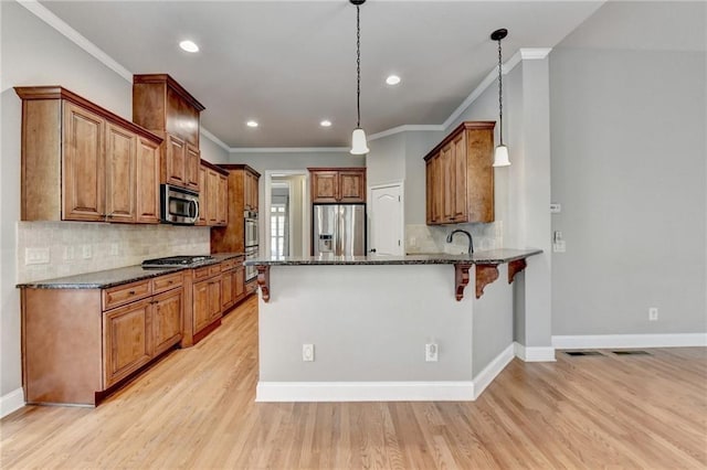5195 Stefan Ridge Way, Buford, GA 30519 - kitchen featuring a peninsula, dark stone countertops, stainless steel appliances, decorative backsplash, and ornamental molding